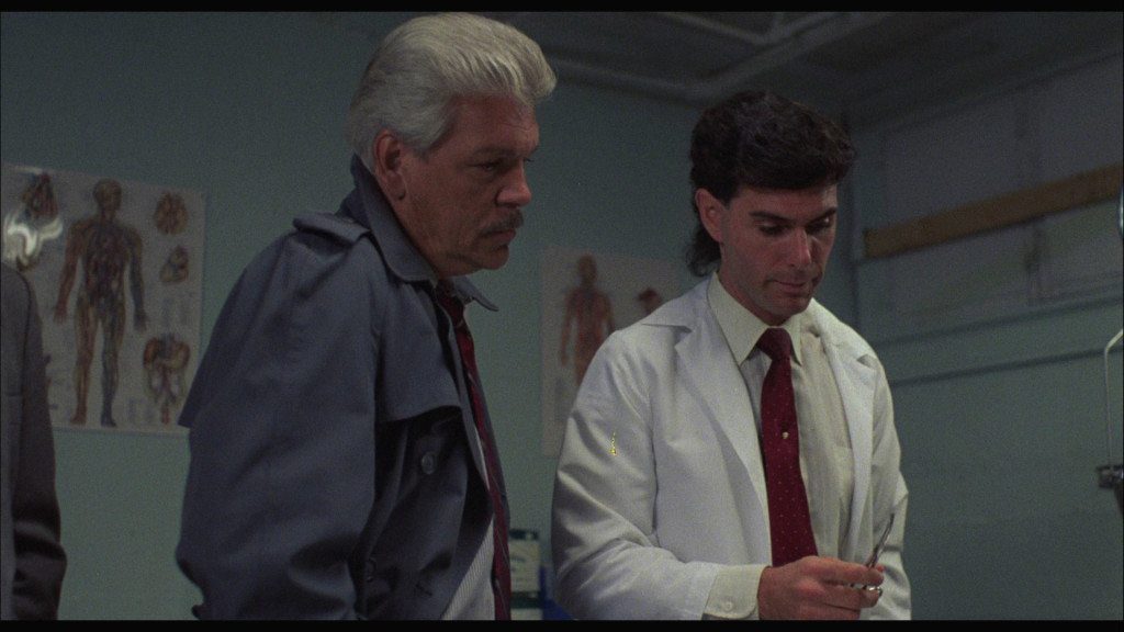 Lieutenant Tom McCrae (L) meets with the coroner to take a closer look at the Maniac Cop's first victim.